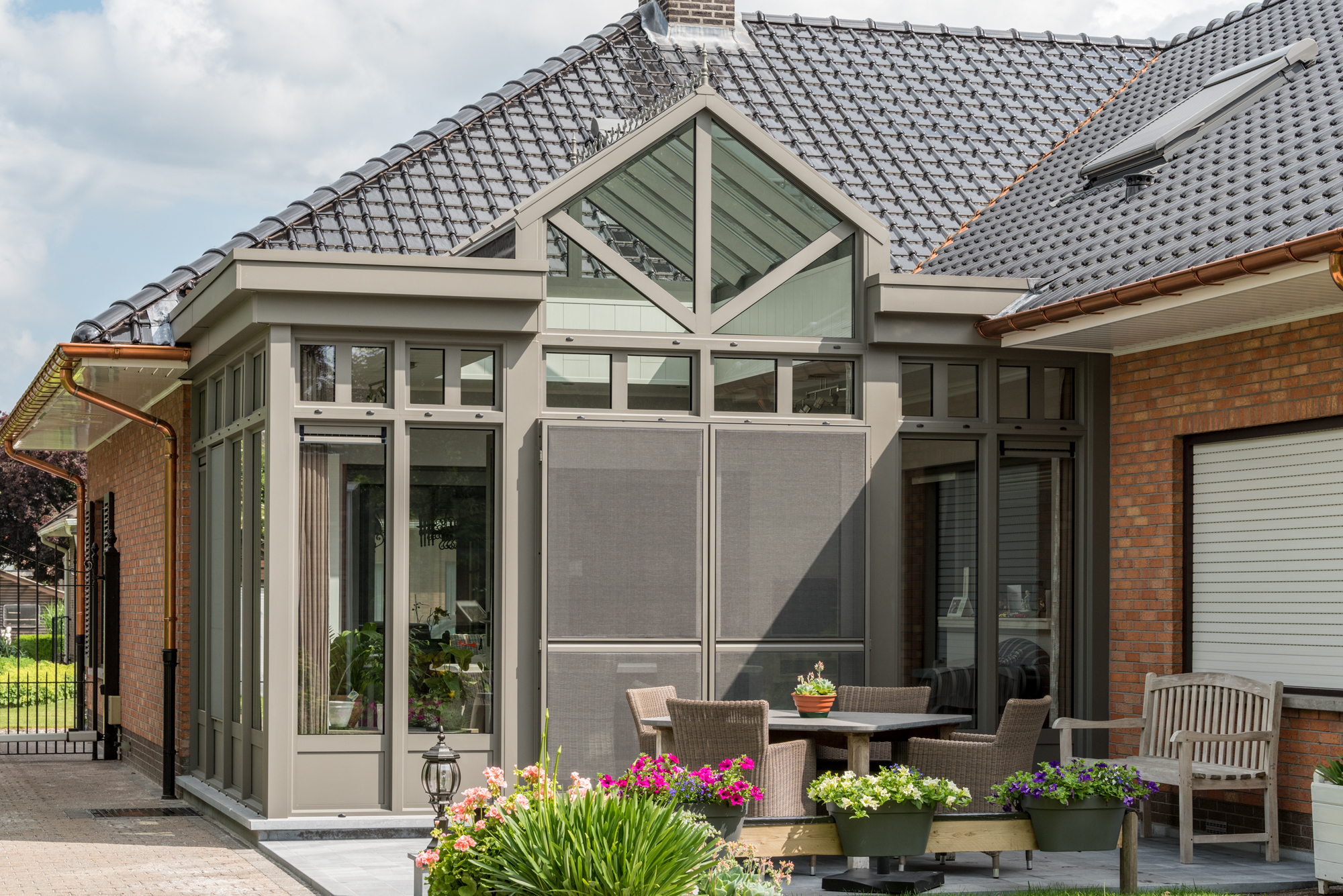 Moderne zwarte aluminium veranda met krachtig lijnwerk en grote glaspartijen, realisatie door Bruynseels-Vochten.