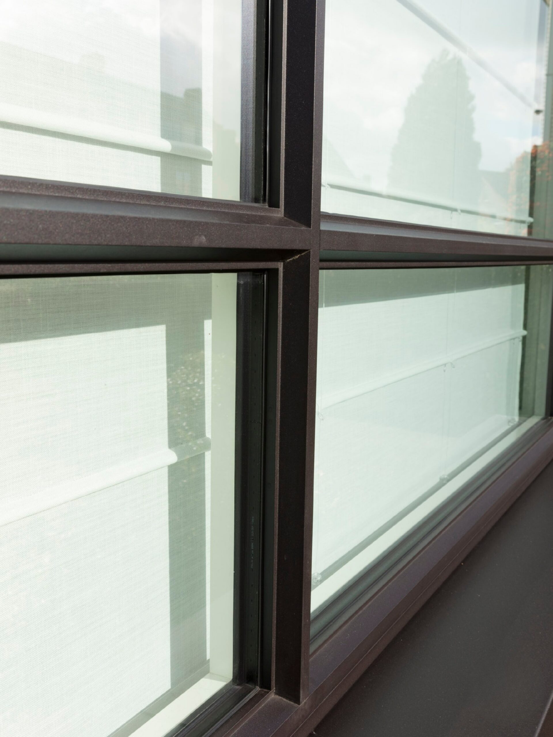 Detail van zwart aluminium raamprofiel met strakke roedes en grote glaspartijen, ontworpen voor maximale lichtinval en een moderne architecturale uitstraling.