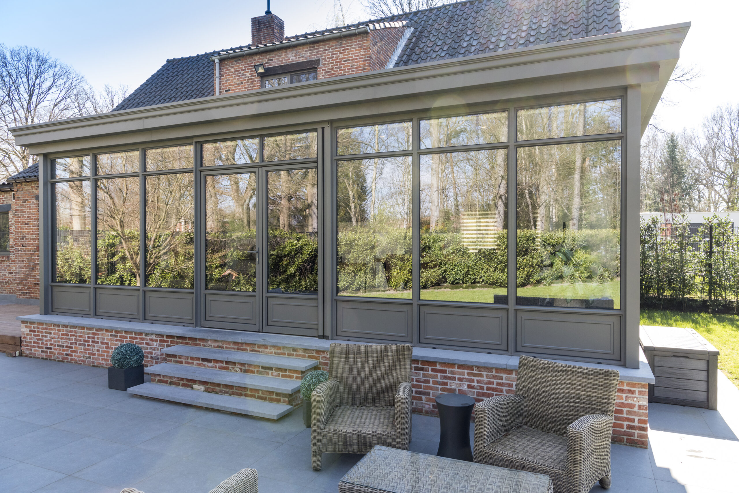 Klassieke houtlook of aluminium veranda in landelijke stijl bij een traditionele woning.